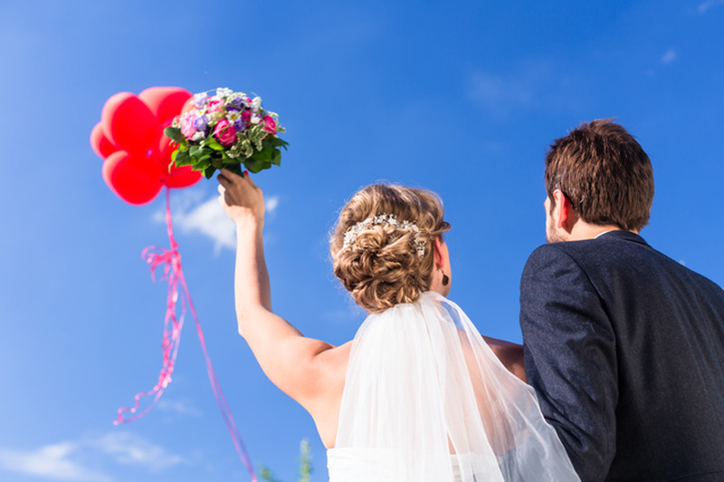 Bride and groom at wedding with helium balloons