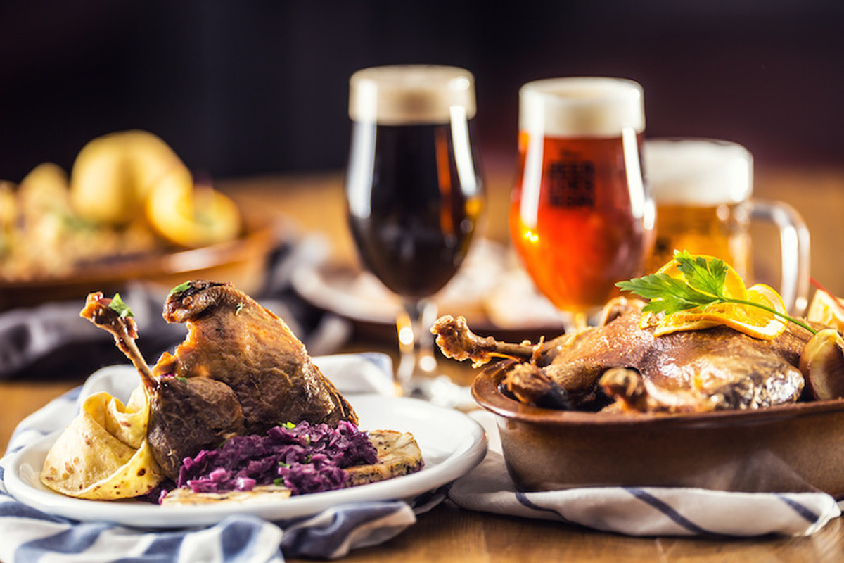 Roasted christmas duck leg red cabbage dumplings liver draft beer and baked buns.