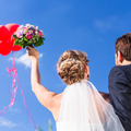 Bride and groom at wedding with helium balloons