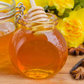 glass jar of floral honey on wooden table