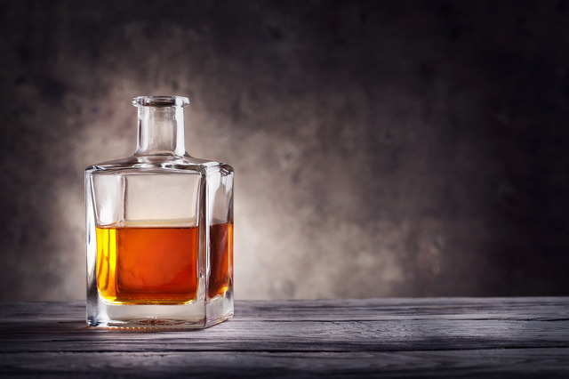 Square decanter of brandy on a dark background